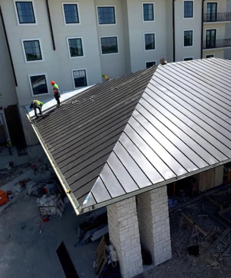 Crew installing standing seam metal roof panels on a commercial project in Phoenixville